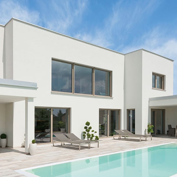 Vista esterna di una villa con piscina, dotata di finestre e porte finestre Internorm