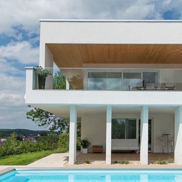 Vista esterna di una villa con piscina, dotata di finestre e porte finestre Internorm